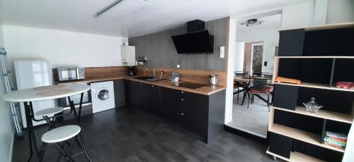 une cuisine avec un comptoir, une table et des chaises dans l'établissement Maison familiale à Gerde, à Gerde