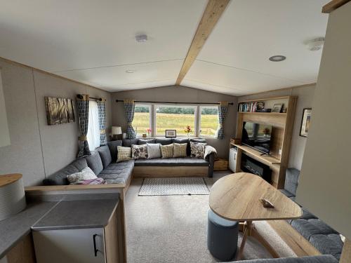 a living room with a couch and a table at Wildcat Lodge Grantown on Spey in Grantown on Spey