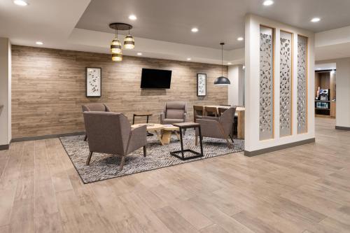 a lobby with chairs and a table and a tv at Candlewood Suites Chambersburg by IHG in Chambersburg