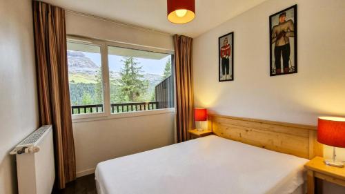 une chambre avec un lit et une grande fenêtre dans l'établissement Résidence Les Pleiades - Appartement lumineux avec balcon · Centre station · Parking couvert MAE-7379, à Flaine