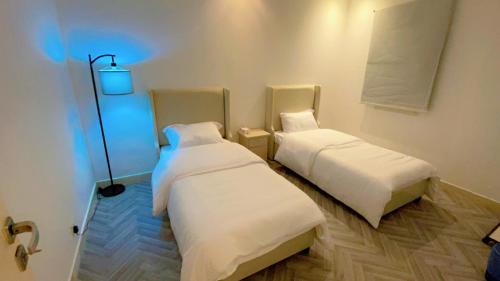 two beds in a room with a blue light at شقة بالكامل حي المعذر 1 in Riyadh
