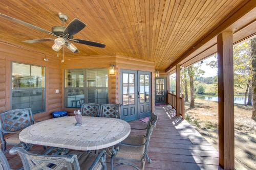 a porch with a table and chairs and a ceiling fan at The Bird Cabin Peaceful Refuge in East Texas in Ben Wheeler