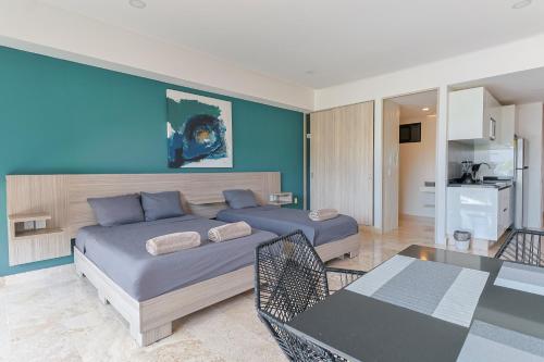 a bedroom with two beds and a blue wall at Torre Diez by Grupo Amber in Playa del Carmen