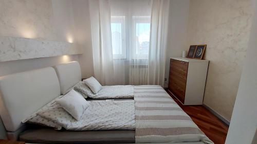 a bedroom with a bed and a dresser and a window at Bella Vista Superior in Umag