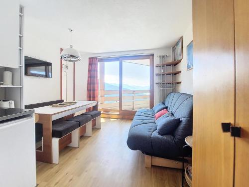 un salon avec un canapé bleu et une table dans l'établissement Résidence Le Valaisan I - Appartement 2 pièces de 32m² pour 5 personnes MAE-8124, à Montvalezan