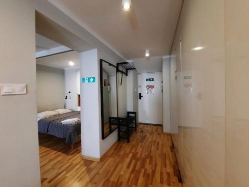 a bedroom with a bed and a mirror in a room at Lorf Hostel&Coffee in Kraków