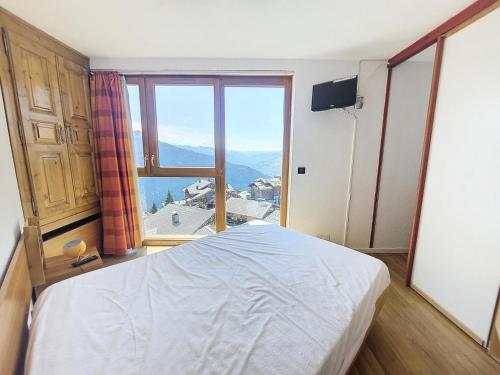 une chambre avec un lit et une grande fenêtre dans l'établissement Résidence Le Valaisan I - Appartement 2 pièces de 32m² pour 5 personnes MAE-8124, à Montvalezan