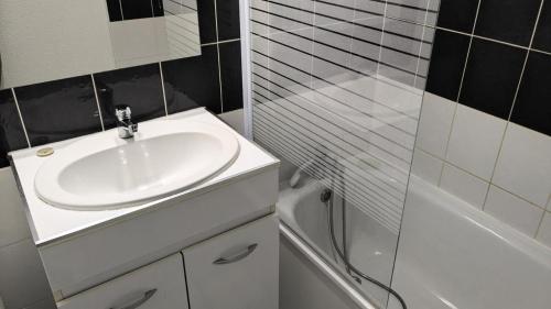 une salle de bain avec un lavabo et une baignoire dans l'établissement Résidence Rond-point-pistes I - Maxi studio 6 pers. n° 44 A le rond point des pistes 1 centre station MAE-0271, à Orcières