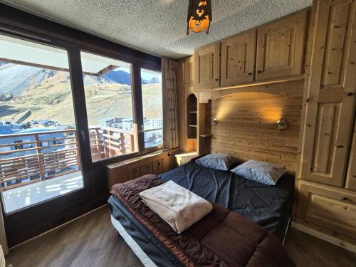une chambre avec un lit et une grande fenêtre dans l'établissement Résidence Curling B Tour - Appartement dans le secteur du Val Claret MAE-2454, à Tignes