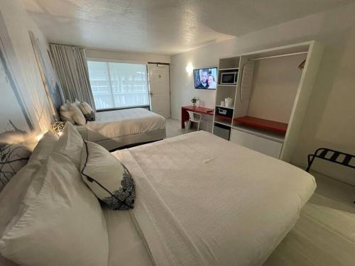 una camera d'albergo con due letti e una televisione di Newly Room in cozy hotel with Super location to the Parks a Kissimmee
