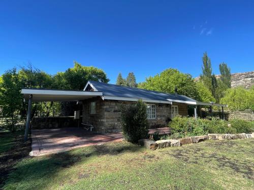 una casa in pietra con tetto a gambero di Periwinkle, Grove ,Acorn & Sage Cottages a Clarens