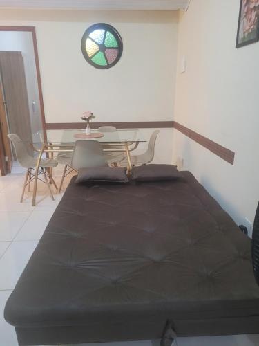 a bedroom with a bed and a table with chairs at Casa aconchegante no Centro da Cidade - Cantinho da Bia MP in Miguel Pereira