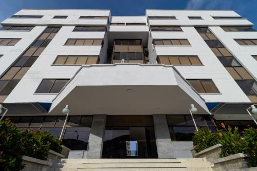 an image of a white building at Hotel Axis Inn By GEH Suites in Santa Marta