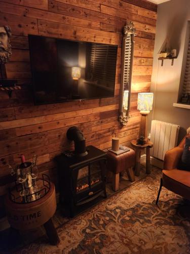 a living room with a fireplace and a television at The lodge in Blackwood