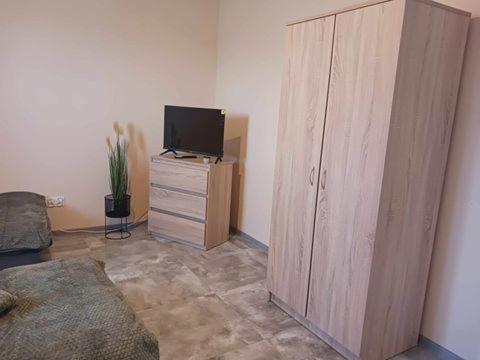 a living room with a television and a wooden cabinet at Pokoje Noclegowe in Kowalów Dolny
