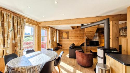 a dining room with a table and a fireplace at Résidence Hameau - Chalet lumineux · Poêle à bois · WIFI gratuit et illimité · Garage MAE-1691 in Magland