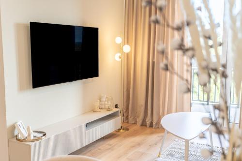 sala de estar con TV y silla blanca en K&M Apartments Near Tauron Arena, en Cracovia