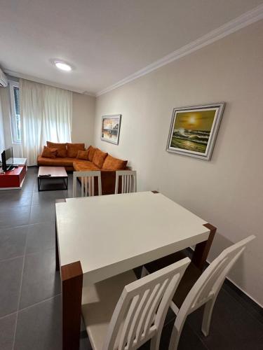 a living room with a table and chairs and a couch at Deluxe Apartments Shengjin in Shëngjin