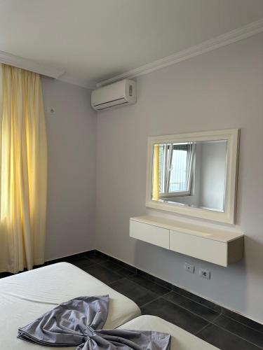 a bedroom with a bed and a mirror on the wall at Deluxe Apartments Shengjin in Shëngjin