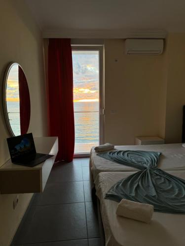 a hotel room with two beds and a large window at Deluxe Apartments Shengjin in Shëngjin