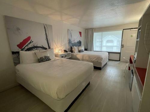 una camera d'albergo con due letti e una finestra di Newly Room in cozy hotel with Super location to the Parks a Kissimmee