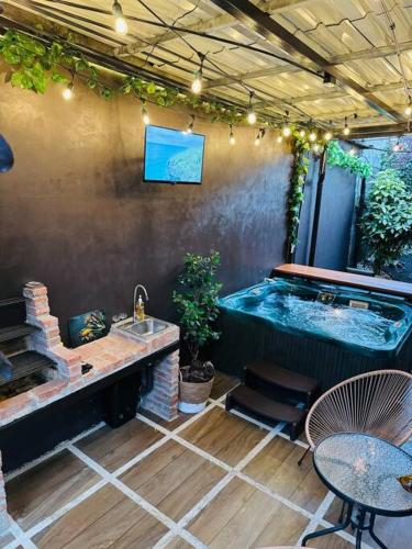 a patio with a hot tub and a table and a sink at Casa Caribe in Guápiles