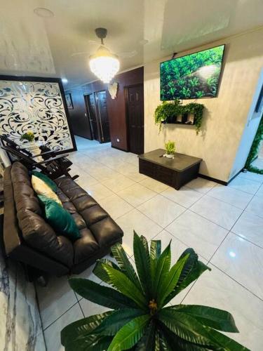 a living room with a leather couch and a table at Casa Caribe in Guápiles