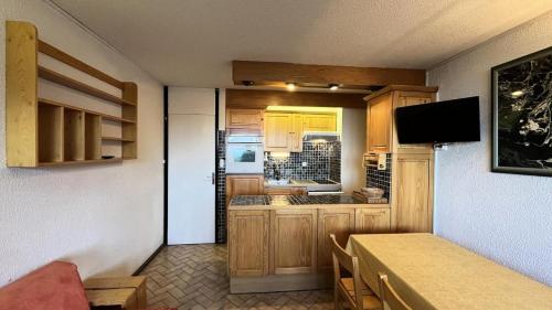 une petite cuisine avec des placards en bois et une table dans l'établissement Résidence Le Mustag - Résidence LE MUSTAG N°R4 MAE-1431, à La Plagne Tarentaise