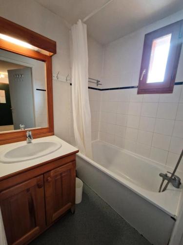 une salle de bain avec un lavabo, une baignoire et un miroir dans l'établissement Les Chalets D'arrondaz - 3 pièces 4/6 personnes MAE-9544, à Modane