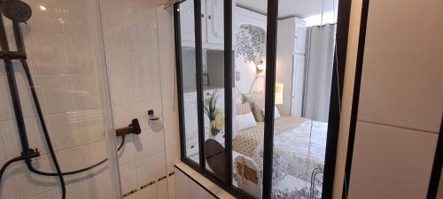 ein Bad mit einer Glasdusche und einem Bett in der Unterkunft Appartement terrasse esprit loft vue sur mer in Erquy