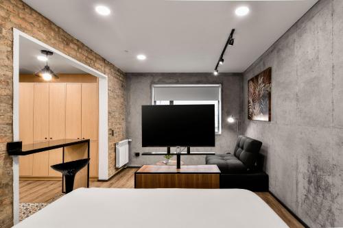 a bedroom with a couch and a flat screen tv at Nova Apartments in Bogotá