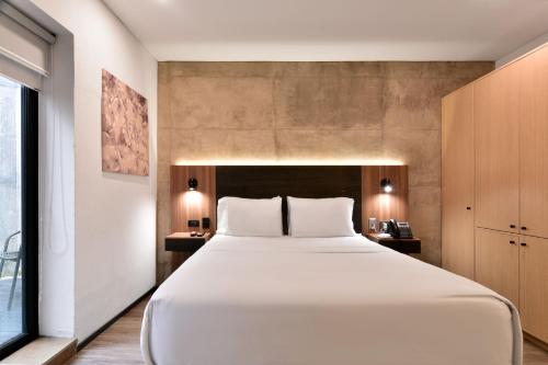 a bedroom with a large white bed in a room at Nova Apartments in Bogotá
