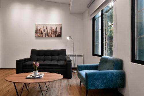 a living room with a couch and a table and chairs at Nova Apartments in Bogotá