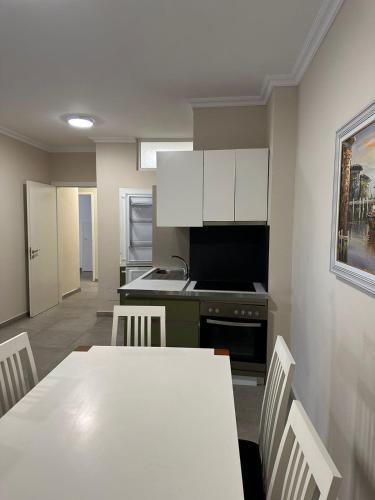 a kitchen with a table with chairs and a stove at Deluxe Apartments Shengjin in Shëngjin