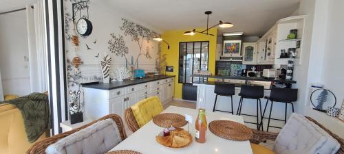 eine Küche mit Tisch und Stühlen in einem Zimmer in der Unterkunft Appartement terrasse esprit loft vue sur mer in Erquy