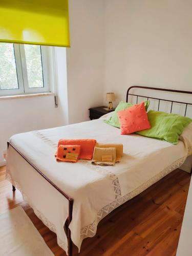 a bedroom with a bed with colorful pillows on it at Casa Morgado by NaturAlegre in Alegrete