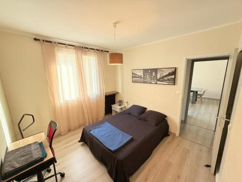 une chambre avec un lit et un bureau dans l'établissement Les Arènes de Nîmes - Centre ville 10 min Gare -Parking- 2 chambres, à Nîmes