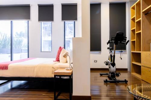 a bedroom with a bed and a camera on a tripod at Urban Puebla by Grupo Amber in Puebla