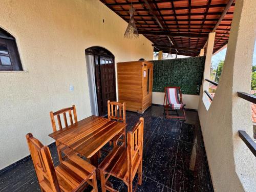 a wooden table and chairs on a patio at Pousada Vila Italia - Porto da Dunas in Aquiraz