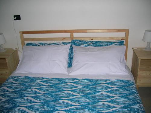 a bed with a blue and white comforter at B&B Al Carotin in Mantello