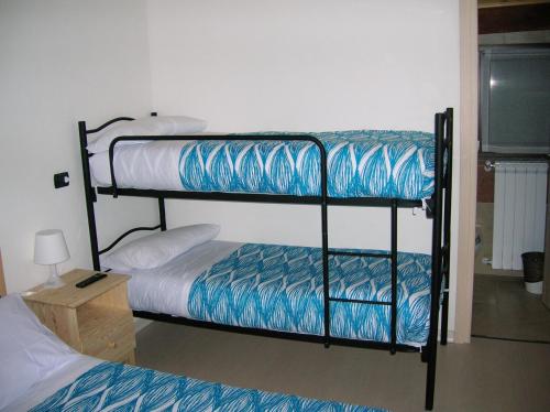 two bunk beds in a room with a television at B&B Al Carotin in Mantello