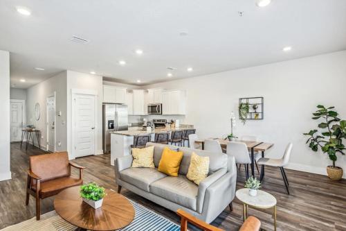 a living room with a couch and a kitchen at LUXURY TOWNHOME NEAR DOWNTOWN AND PENSACOLA BEACH in Pensacola