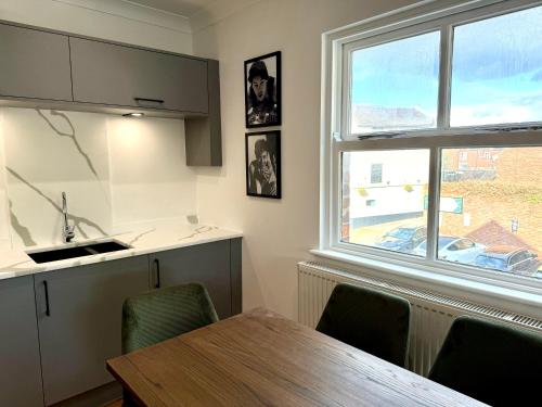 a kitchen with a dining table and a window at 3 bed flat in Holmes Chapel Harry Styles village in Holmes Chapel