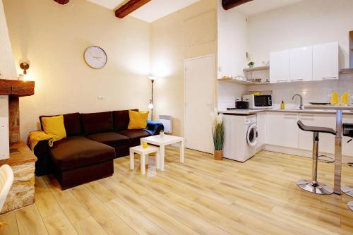 un salon avec un canapé et une cuisine dans l'établissement Le Soleil Bleu, à Nîmes