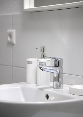 a bathroom sink with a faucet and toilet paper at Smart 1 in Tuttlingen