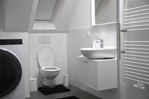 a white bathroom with a toilet and a sink at Smart 1 in Tuttlingen