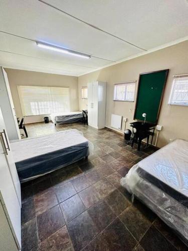 a bedroom with two beds and a greenboard in it at Kelello House House in Welkom