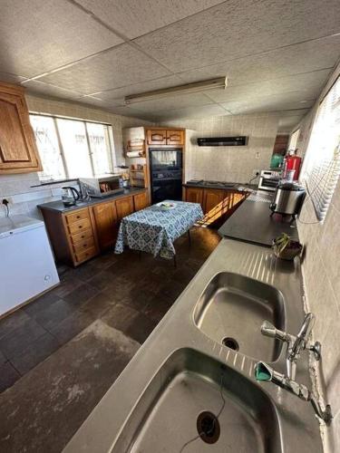 a kitchen with a sink in the middle of it at Kelello House House in Welkom