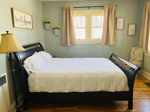 a bedroom with a bed with a lamp and a window at Walk to Dining Breweries and Shops Plus New Hot Tub in Louisville