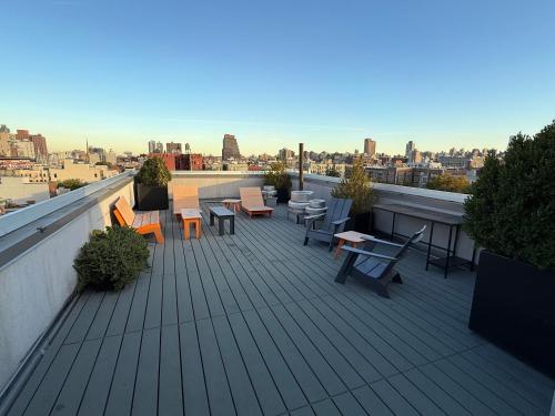 a deck with tables and chairs on a roof at Modern Studio with Private Bathroom and Kitchen in New York